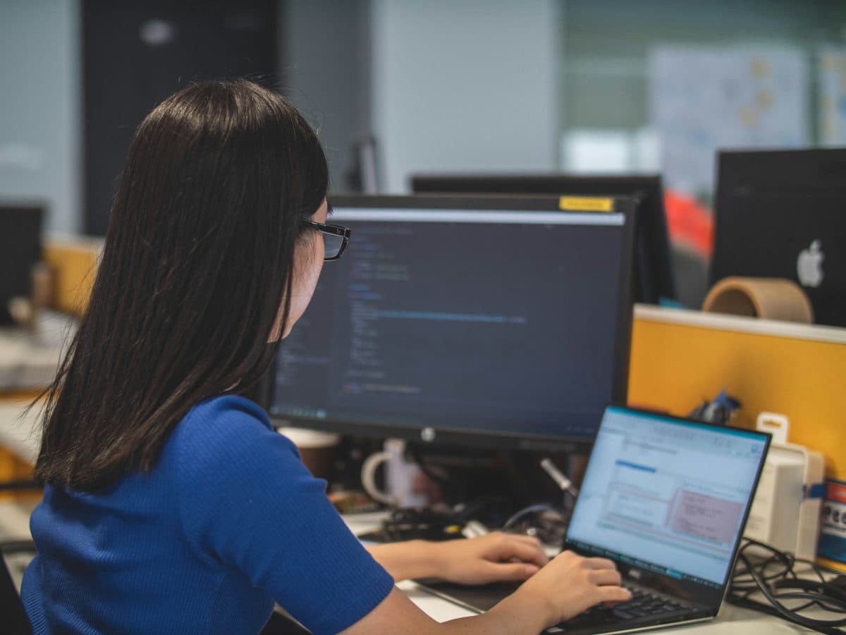 Mitarbeiterin im Back-Office prüft Belege am Bildschirm